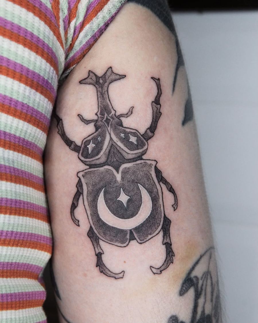 Tatuaje de un escarabajo con una luna en el brazo