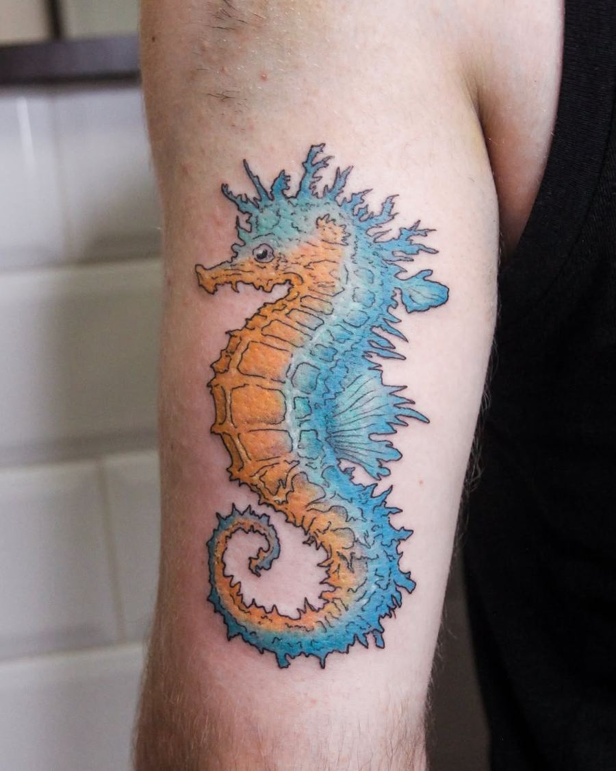 Tatuaje a color de un caballito de mar en el brazo